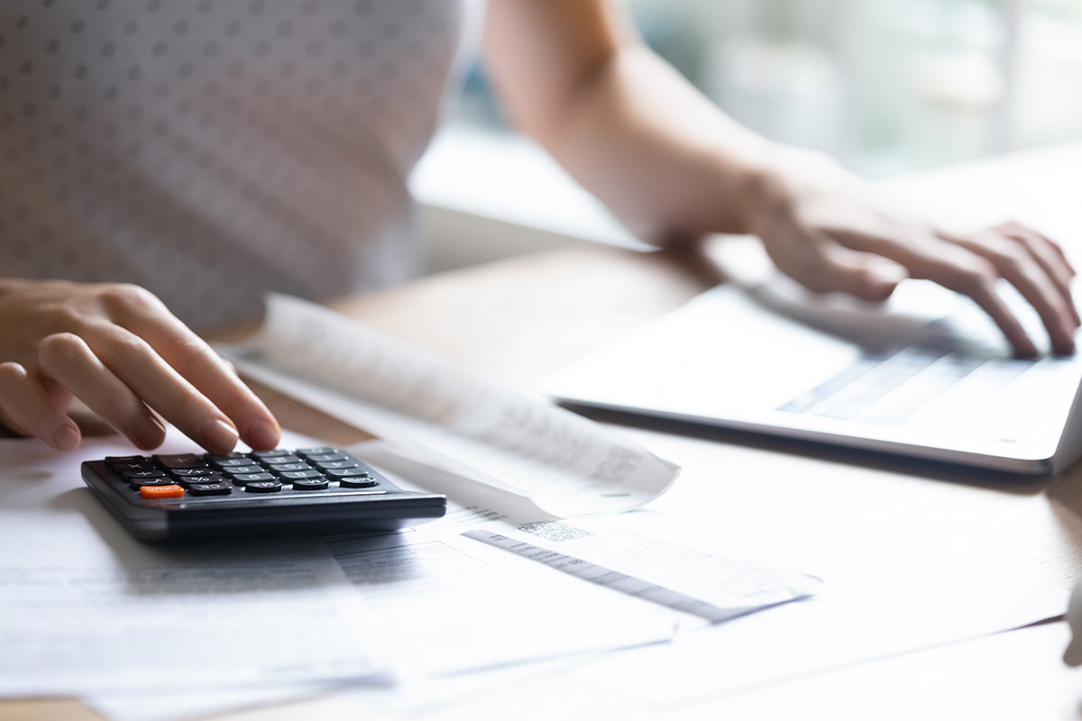 close up of person typing on calculator with lots of paperwork in front of them wondering what to do if I can't pay my medical bills